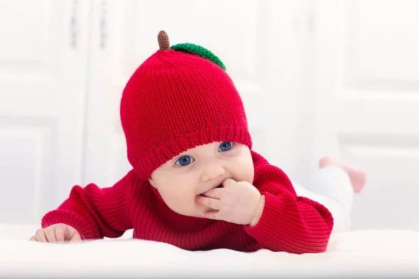 リンゴの帽子をかぶった赤ちゃんベッドの上の子供自宅の子供. — ストック写真