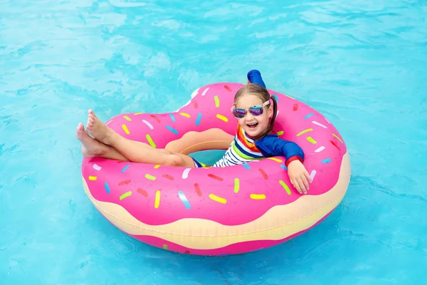 Niño en piscina con flotador de rosquillas — Foto de Stock