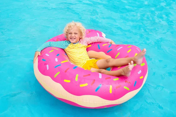 Ребенок в бассейне на пончиковой платформе — стоковое фото
