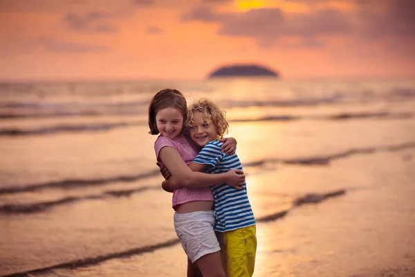 Niño jugando en la playa del océano. Niño al atardecer mar . —  Fotos de Stock