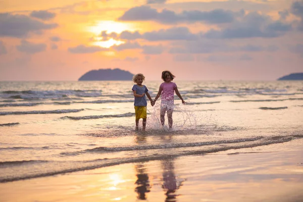 Dítě hrající na pláži u oceánu. Kluk na západu slunce moře. — Stock fotografie
