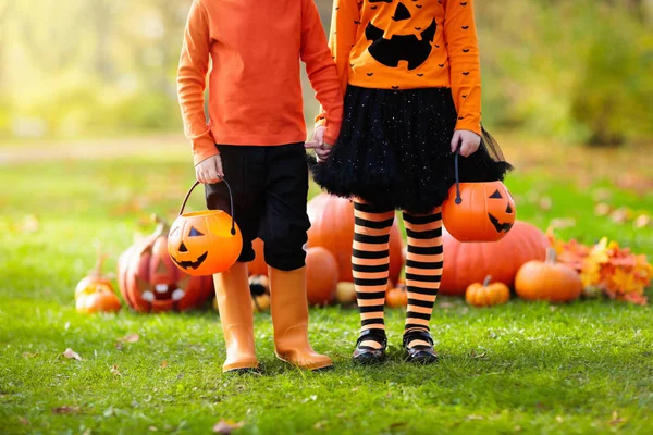 Barn med pumpor i Halloween kostymer — Stockfoto