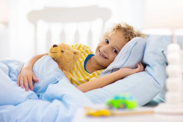 Criança brincando na cama. Quarto de crianças. Menino em casa . — Fotografia de Stock