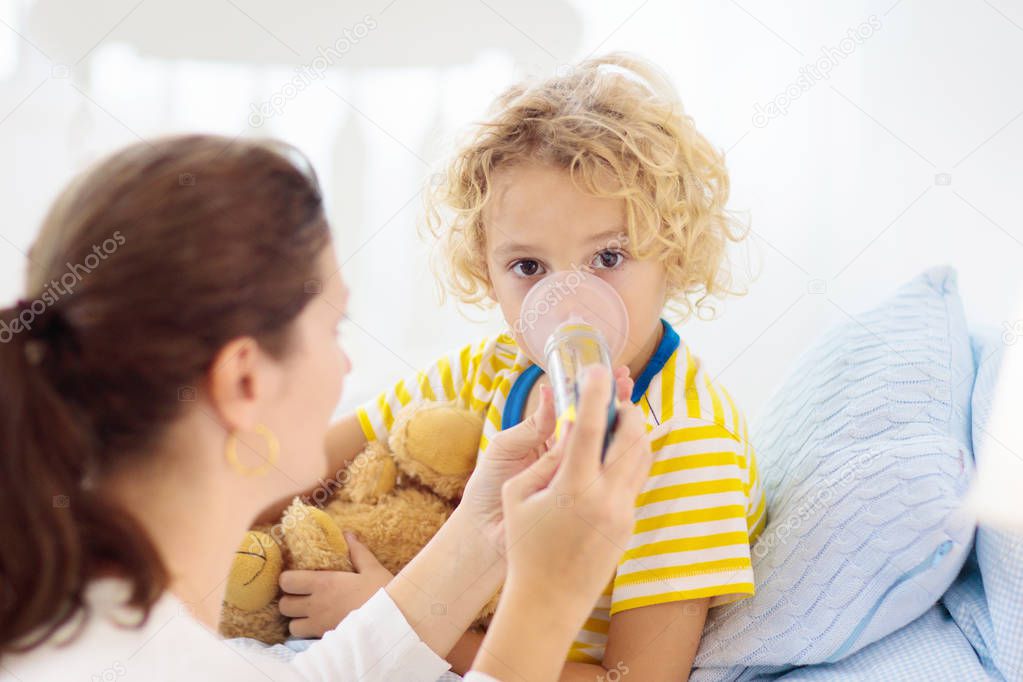 Sick little boy with asthma medicine. Ill child.