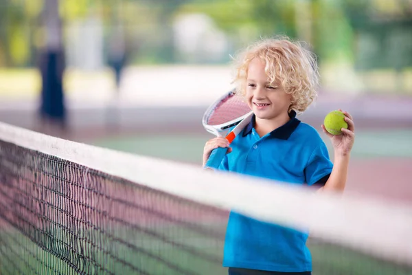 Enfant jouant au tennis sur un court extérieur — Photo