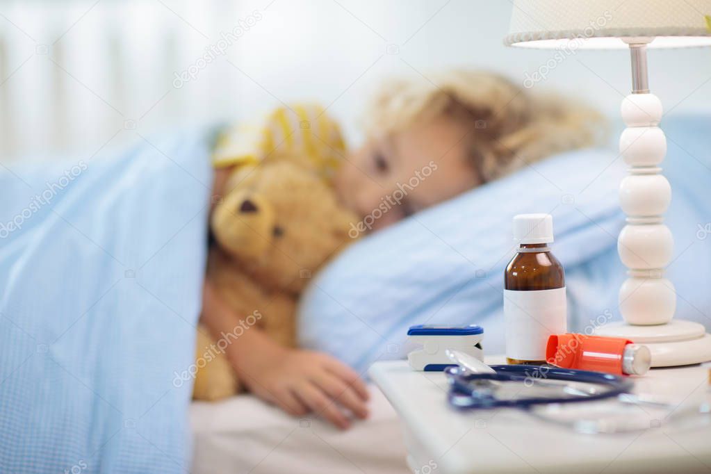 Sick little boy with asthma medicine. Ill child.