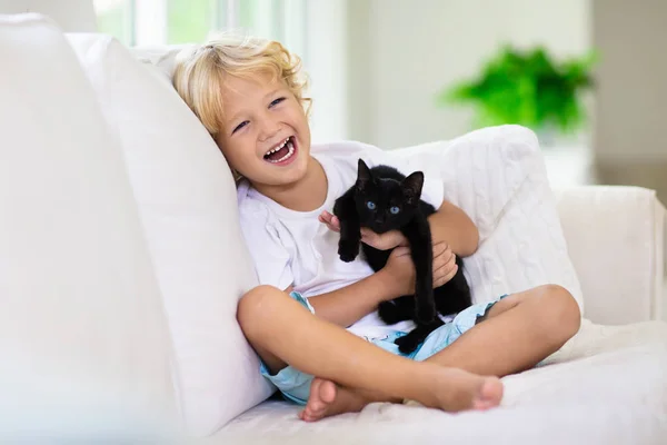 Dítě si hraje s kočičím. Dítě a kotě. — Stock fotografie