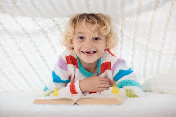 Livro de leitura infantil na cama. Crianças lêem livros . — Fotografia de Stock