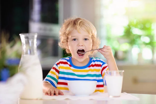 Child eating breakfast. Kid with milk and cereal. — Stock Photo, Image