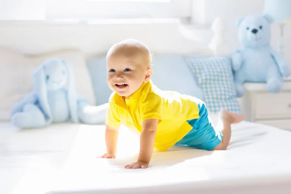 Bambino che gioca sul letto in vivaio soleggiato — Foto Stock