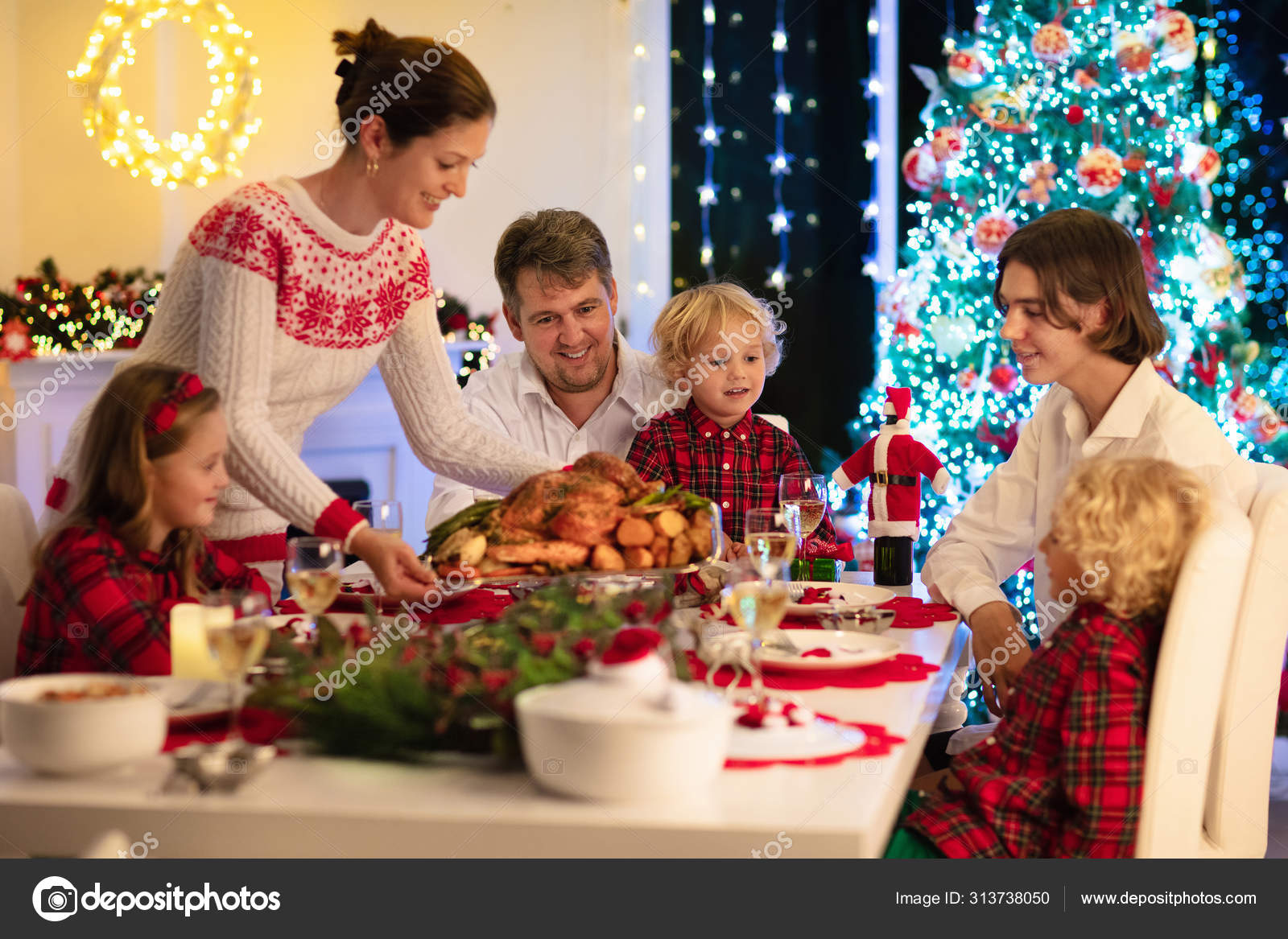 Family With Kids Having Christmas Dinner At Tree Stock Photo Image By C Famveldman 313738050