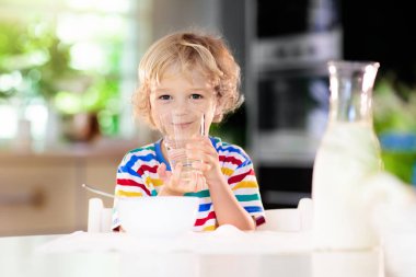 Çocuk kahvaltı yapıyor. Süt ve tahıl ile çocuk.