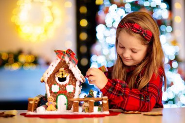 Çocuklar zencefilli kurabiye evi yapıyor. Evde Noel.