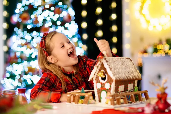 子供たちはジンジャーブレッドハウスを焼く。家でクリスマス. — ストック写真