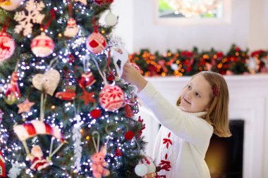 Noel ağacını süsleyen çocuk. Xmas arifesindeki çocuk.