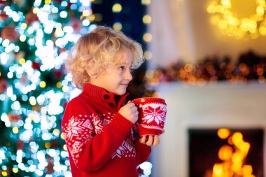 Noel ağacındaki çocuklar. Çocuklar sıcak kakao içer..