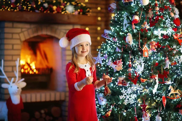 Dítě na vánoční strom a krb na Vánoce — Stock fotografie