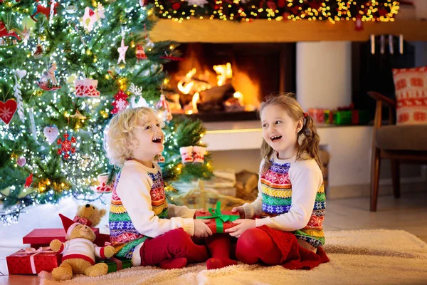 Niño en el árbol de Navidad. Niños en la chimenea en Navidad — Foto de Stock