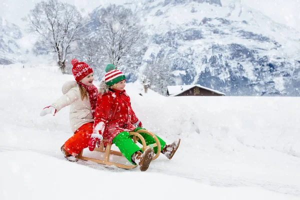 As crianças brincam na neve. Passeio de trenó de inverno para crianças — Fotografia de Stock