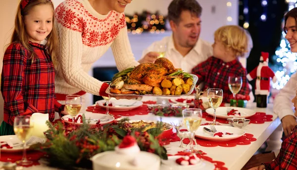Family with kids having Christmas dinner at tree — Stock Photo, Image