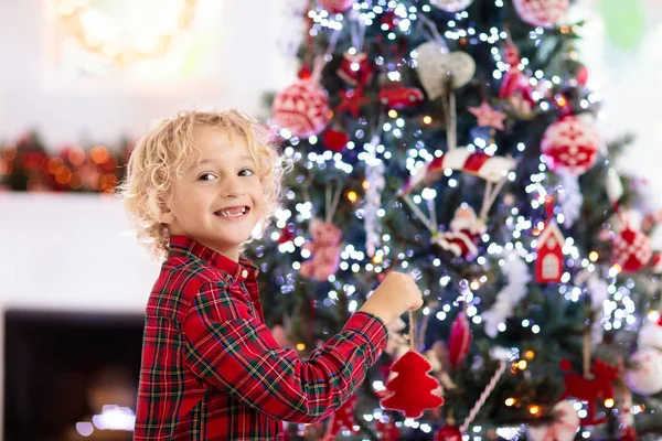 Noel ağacını süsleyen çocuk. Xmas arifesindeki çocuk. — Stok fotoğraf