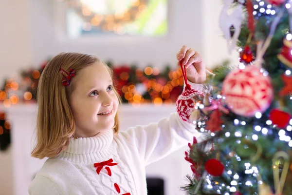 Dítě zdobí vánoční stromek. Dítě na Štědrý večer. — Stock fotografie