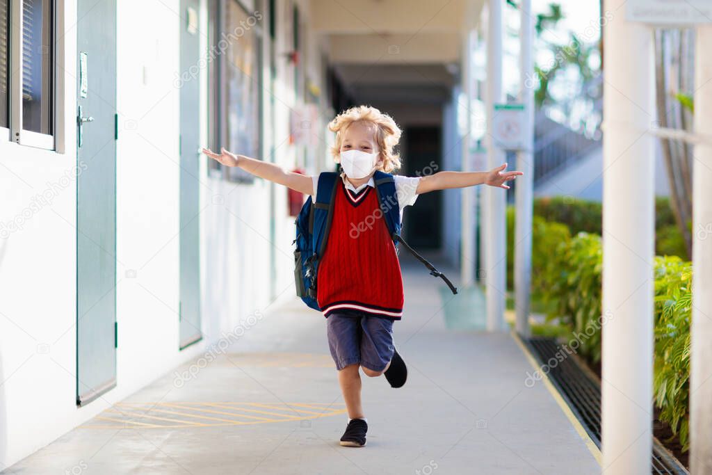 Child wearing face mask during corona virus and flu outbreak. Disease and illness protection for kids. Surgical masks for coronavirus prevention. School kid coughing. Little boy going to school.