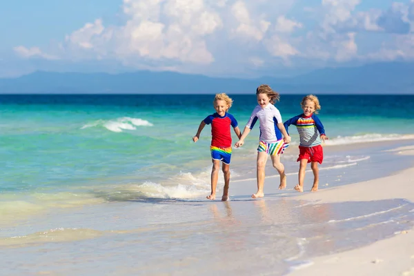 孩子们在热带海滩玩耍 孩子们在暑假时在海上游泳和玩耍 沙子和水的乐趣 防晒幼儿 小男孩和小女孩在海滨跑来跑去 — 图库照片