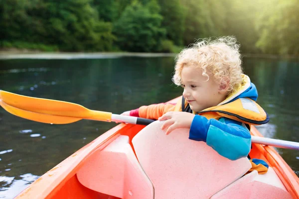 在皮划艇上划桨的孩子 孩子们夏令营 皮划艇和独木舟与家人 独木舟上的孩子骑皮划艇的小男孩 放暑假的野生自然和水的乐趣 露营和捕鱼 — 图库照片