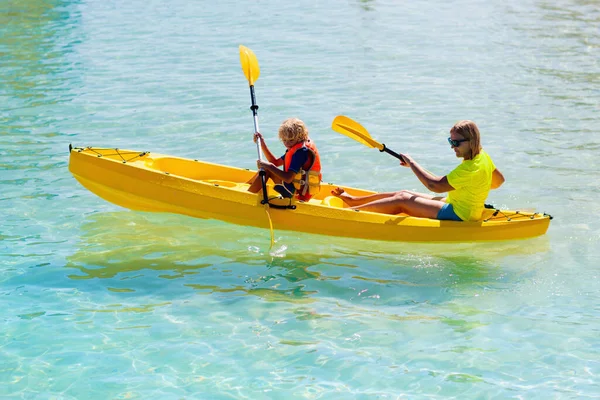 孩子们在海里划船 热带海域皮划艇的孩子们 和小孩一起积极度假父母 小男孩和小女孩在美丽海滩上的独木舟上 和孩子一起参加节日活动 家庭用水乐趣 — 图库照片