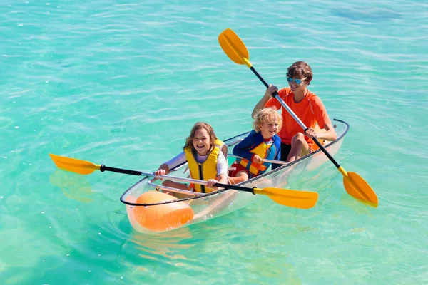 子供たちは海でカヤック 熱帯の海でカヤックの子供たち 若い子供とのアクティブな休暇 美しいビーチでカヌーの両親 男の子と女の子 子供との休日の活動 家族の水の楽しみ — ストック写真