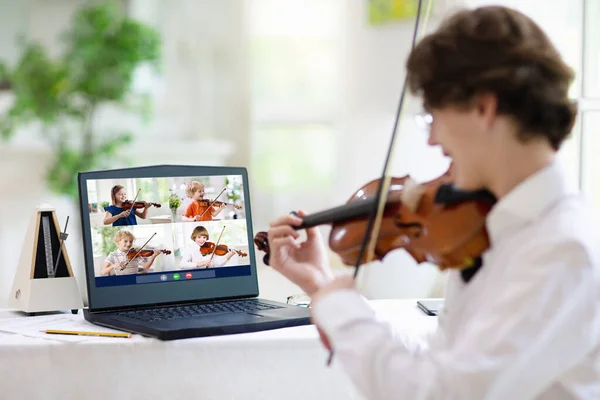 Violin lesson online. Teacher and child play violin via computer. Remote learning from home. Arts for kid. Kids with musical instrument. Video chat conference. Online music tuition. Homeschooling.