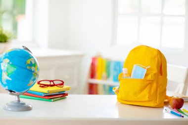 Sırt çantası, yüz maskesi ve dezenfektanı olan bir okul çocuğu. Coronavirus salgınından sonra öğrenci güvenliği. Çocuklar için virüs ve hastalık önleme. Covid-19 salgınından sonra okula ve anaokuluna döndüm..