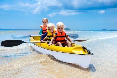 Çocuklar okyanusta kayak yapıyor. Tropikal denizde kanodaki çocuklar. Genç bir çocukla aktif tatil. Oğlan ve kız kanodaki güzel sahilde. Anaokulu çocuğuyla tatil aktivitesi. Aile suyu eğlencesi.