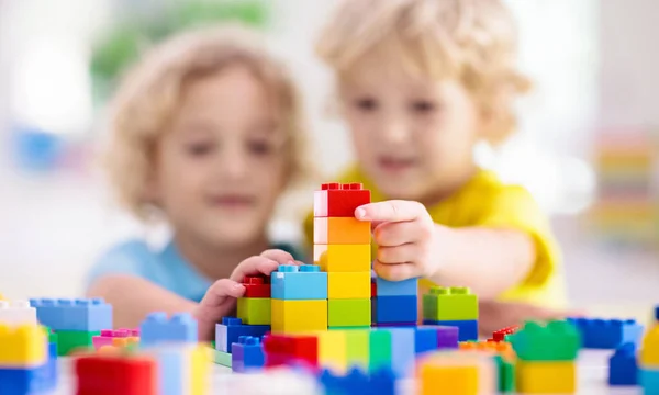 子供たちはカラフルなブロックで遊ぶ 自宅やデイケアで小さな男の子の建物の塔 子供のための教育玩具 赤ちゃんや幼児の子供のための建設創造的なゲーム 幼稚園の遊び場でメス — ストック写真