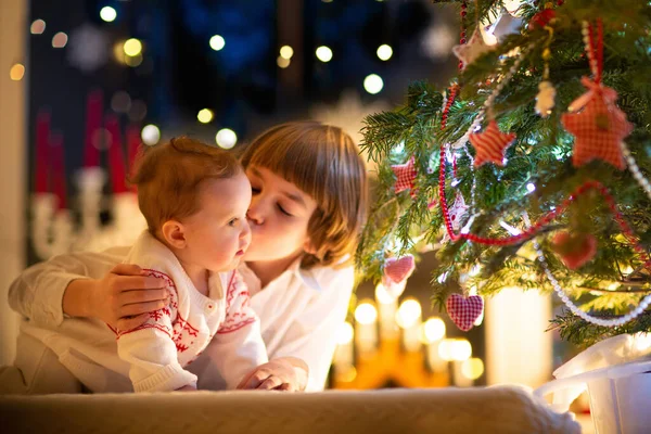 クリスマスツリーの子供たちとクリスマスの前夜の暖炉 自宅でクリスマスを祝う子供たちと家族 夏の木やオープニングプレゼントを飾るパジャマを着た男の子と女の子 子供のための休日の贈り物 — ストック写真