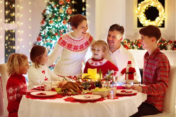 暖炉で七面鳥のクリスマスディナーを食べ クリスマスツリーを飾る子供たちと家族 お祝いの食事で両親 祖父母 冬の休日のお祝いや食べ物 子供たちのプレゼント — ストック写真
