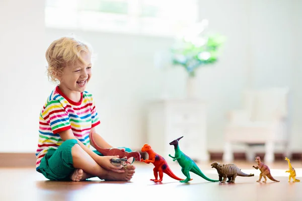 カラフルなおもちゃの恐竜と遊ぶ子供 子供のための教育玩具 化石や爬虫類を学ぶ少年 子供たちは恐竜のおもちゃで遊ぶ 子供のための進化と古生物学ゲーム — ストック写真