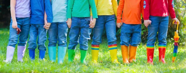 雨のブーツの子供たち カラフルなゴムブーツや秋のジャケットで幼稚園の子供たちのグループ 雨の秋のための履物 子供や赤ちゃんのための足の摩耗 ウェリーの幼児 レインボーガンブーツ キッドファッション — ストック写真