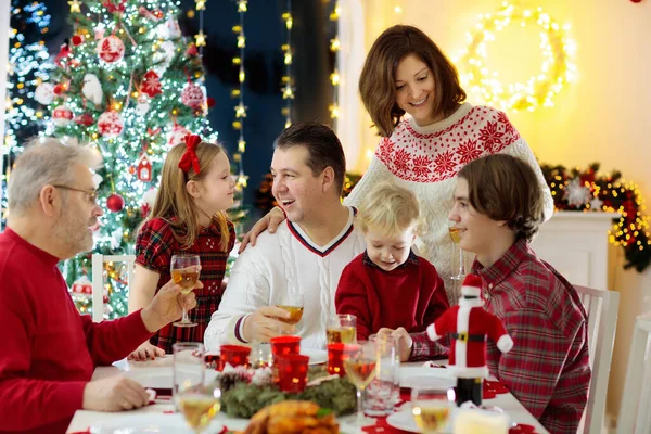 暖炉でクリスマスディナーを食べ クリスマスツリーを飾る子供たちと家族 お祝いの食事で両親 祖父母 冬の休日のお祝いや食べ物 プレゼントやプレゼントを開く — ストック写真