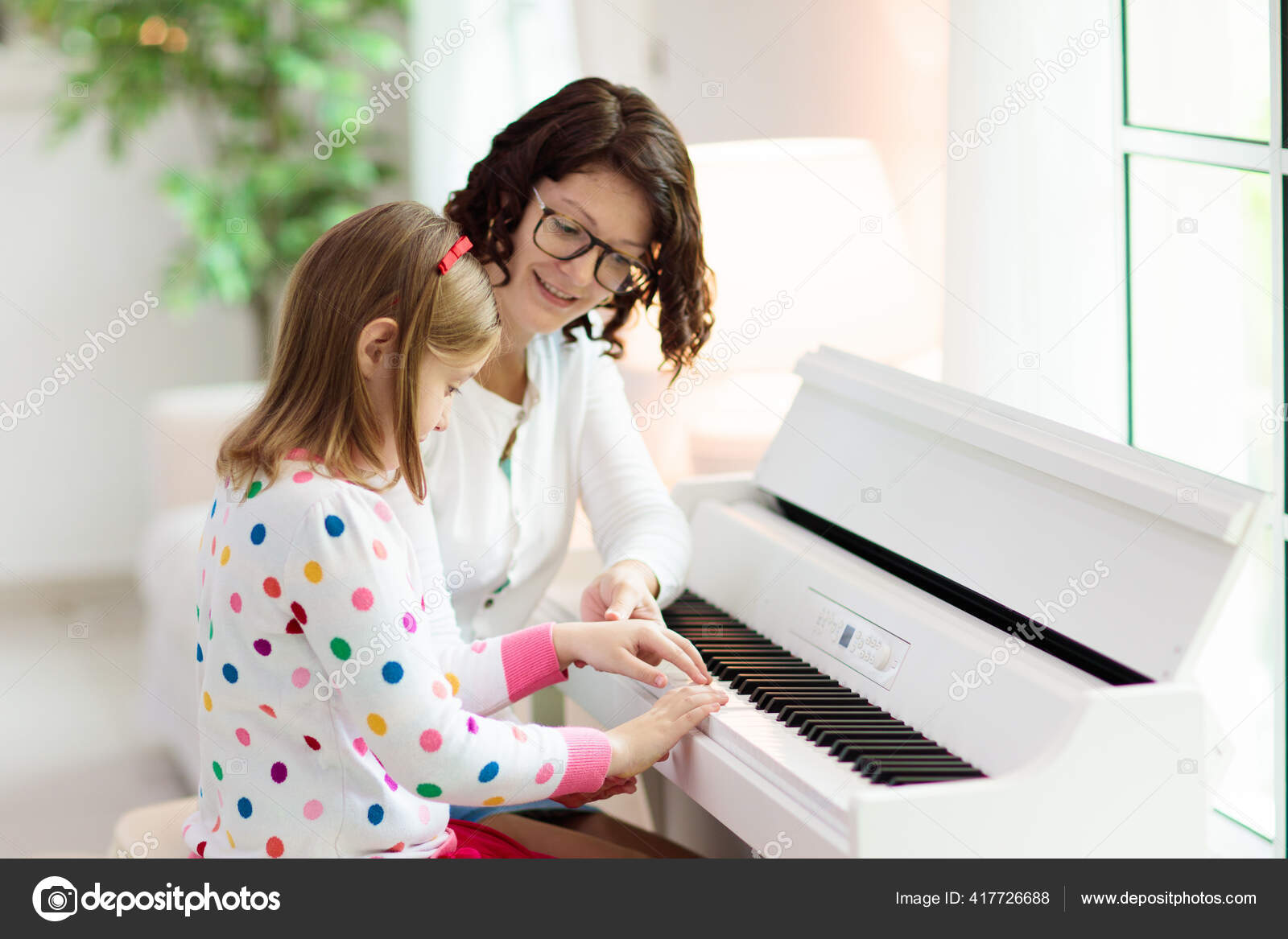 Menina aprende a tocar piano com música online para ensino à