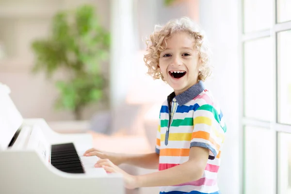 孩子弹钢琴 孩子们弹奏音乐 儿童的经典教育 艺术课 小男孩在白色数字键盘 年轻学生的乐器 学校或家里的音乐课 — 图库照片