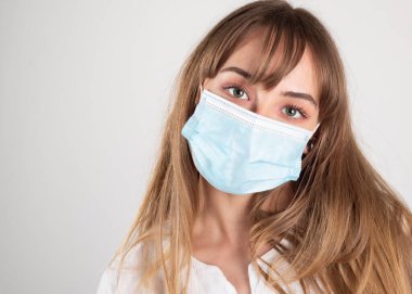 Salgın koronavirüs. Hastalıklara karşı korunmak için antiviral tıbbi maske, samimi bakışlı kadın.