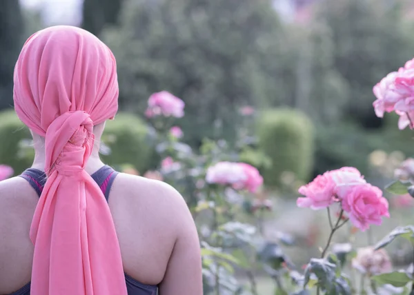 woman with cancer pink scarf on her back