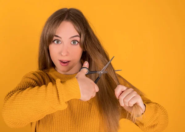 woman cutting her hair with scissors with uncertain face