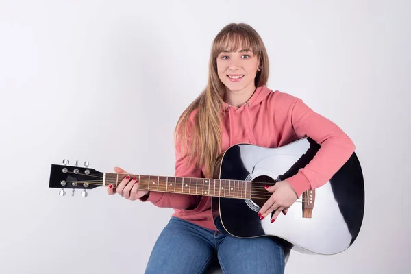 girl playing the guitar to share it on social networks. Using the concept of social media influencer for vlog.