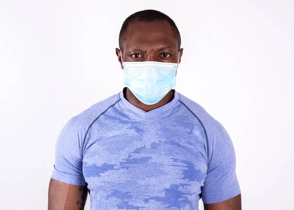 Koronavirüs tıbbi maskesi takan güçlü bir Afro-Amerikan erkeği.