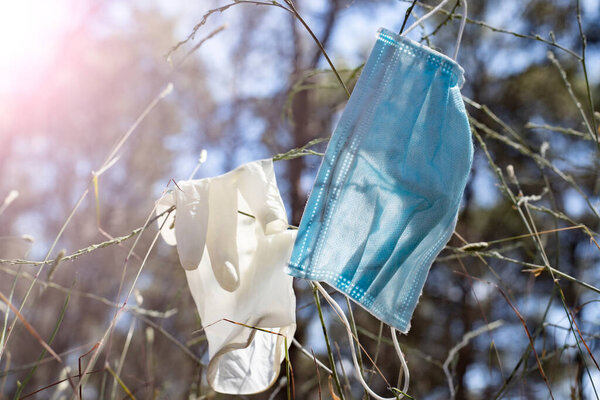 mask and gloves thrown in nature, contamination