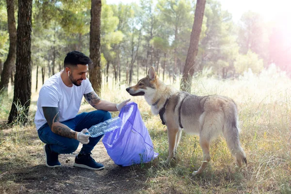 Homem Voluntário Pegando Garrafas Plástico Uma Floresta Com Seu Cachorro — Fotografia de Stock