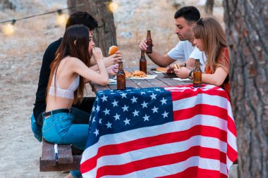 Bir grup genç dışarıda parti veriyor ve bira içiyor.